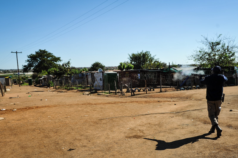 A police officer fires off rubber bullets at residents of Soshanguve Block KK during a service delivery protest, they demand to have proper electricity and housing and vowed to continue their protest untill their needs are met, 17 May 2017, Soshanguve, Pretoria. Picture: Jacques Nelles