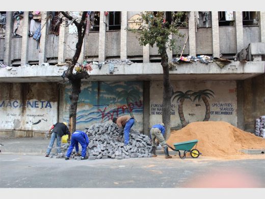 Workers prepare bricks and sand in an effort to seal off the entrance to the hijacked Cape York building in the Johannesburg CBD following a fire that ravaged the building on 5 July. Picture: Tshepiso Mametela