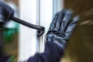 A burglar opens a window with a breaker.