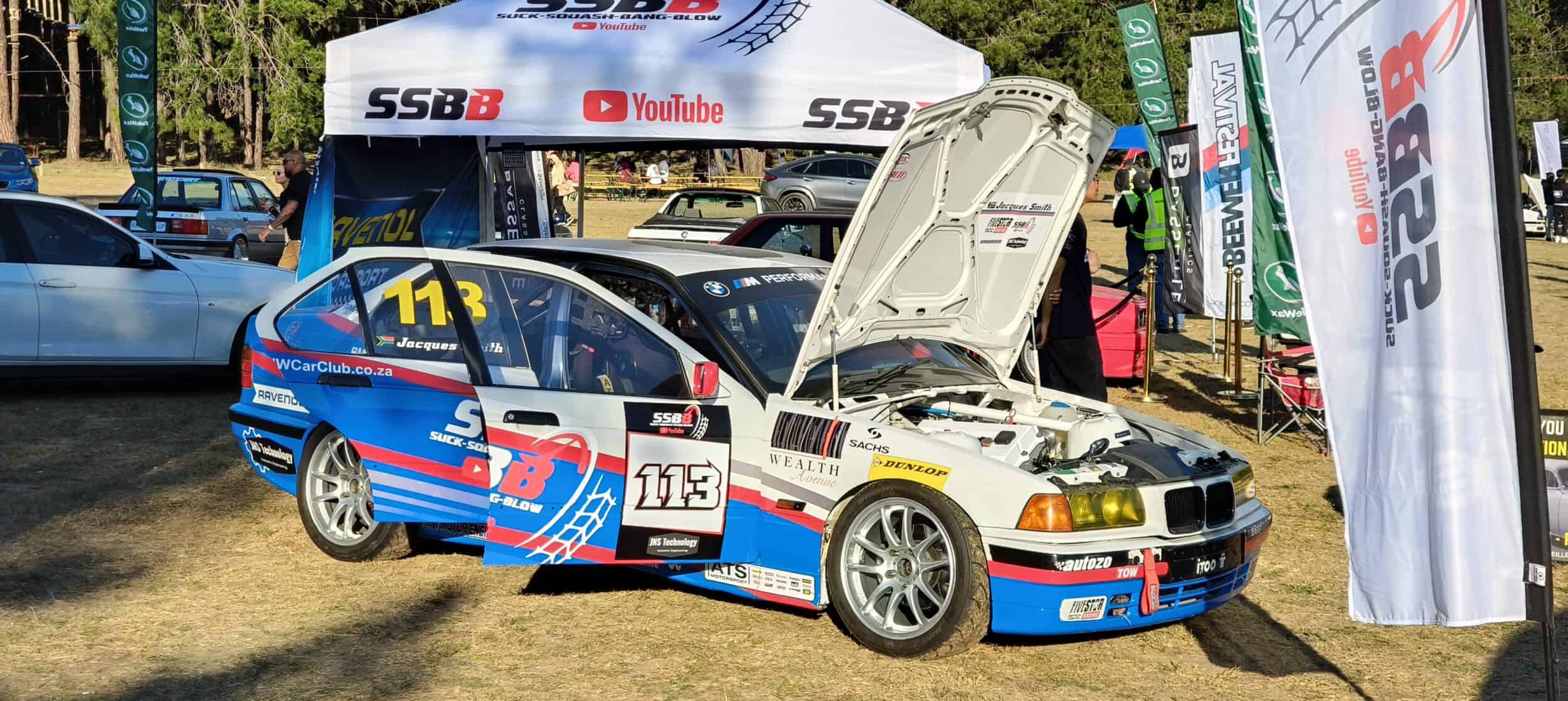 A BMW E36 racing car at a car show