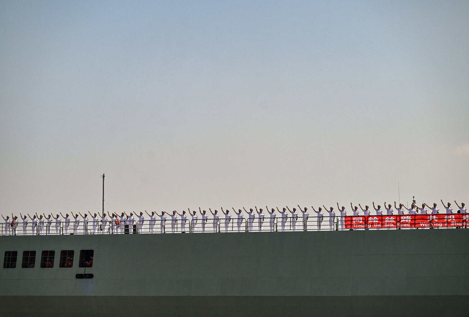 Crew members of Chinese People's Liberation Army (PLA) navy ship Kunlun Shan wave as their ship prepares to dock at Tanjung Perak Port in Surabaya on August 2, 2026, in response to an invitation from the Indonesian Navy. (Photo by JUNI KRISWANTO / AFP)